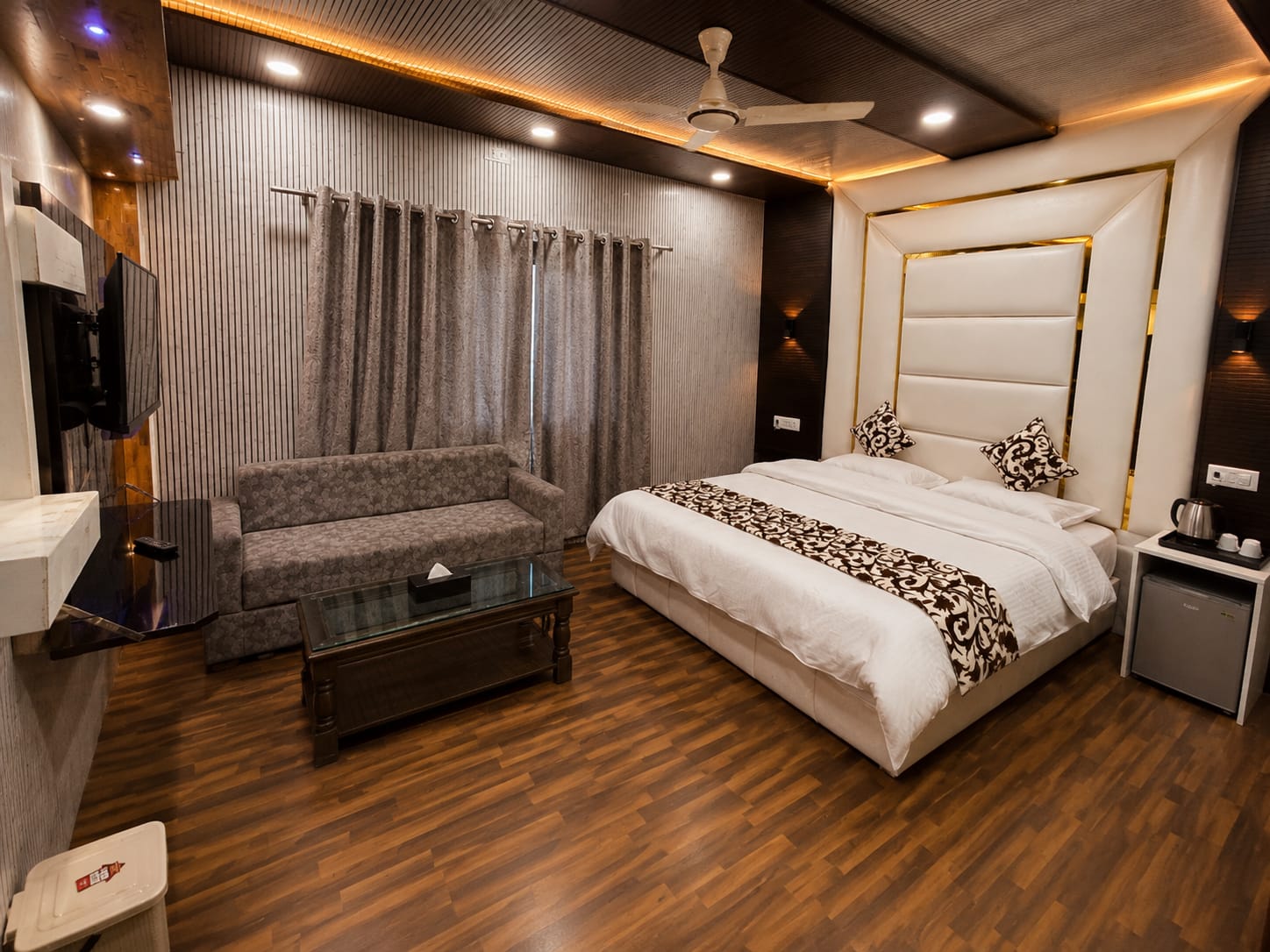 Premium suite with warm wood flooring and lounge seating